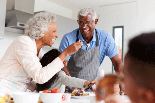 older couple in kitchen with grandchildren