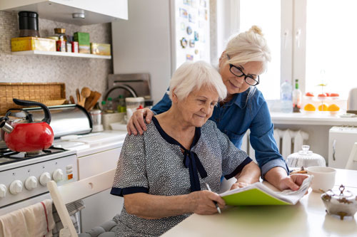 Woman assists older woman with memory task
