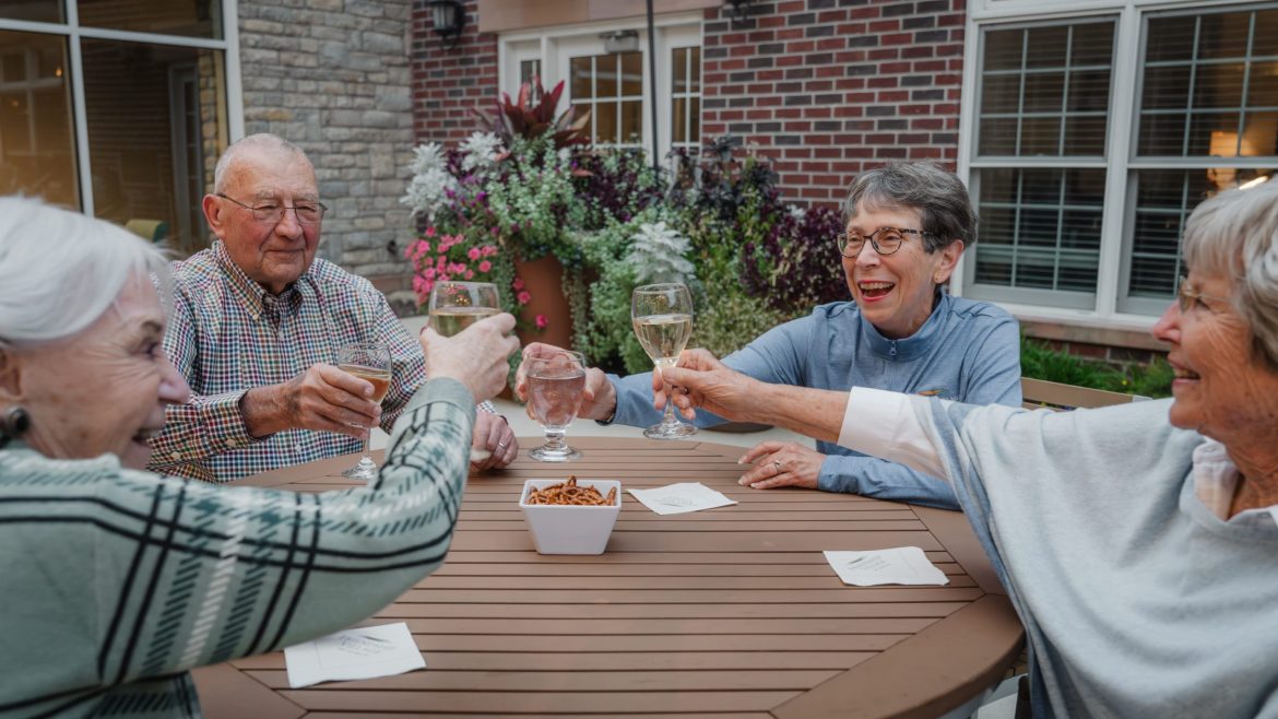 Group of older adults toast one another at an event at Friendship Village of Dublin in Dublin, Ohio.