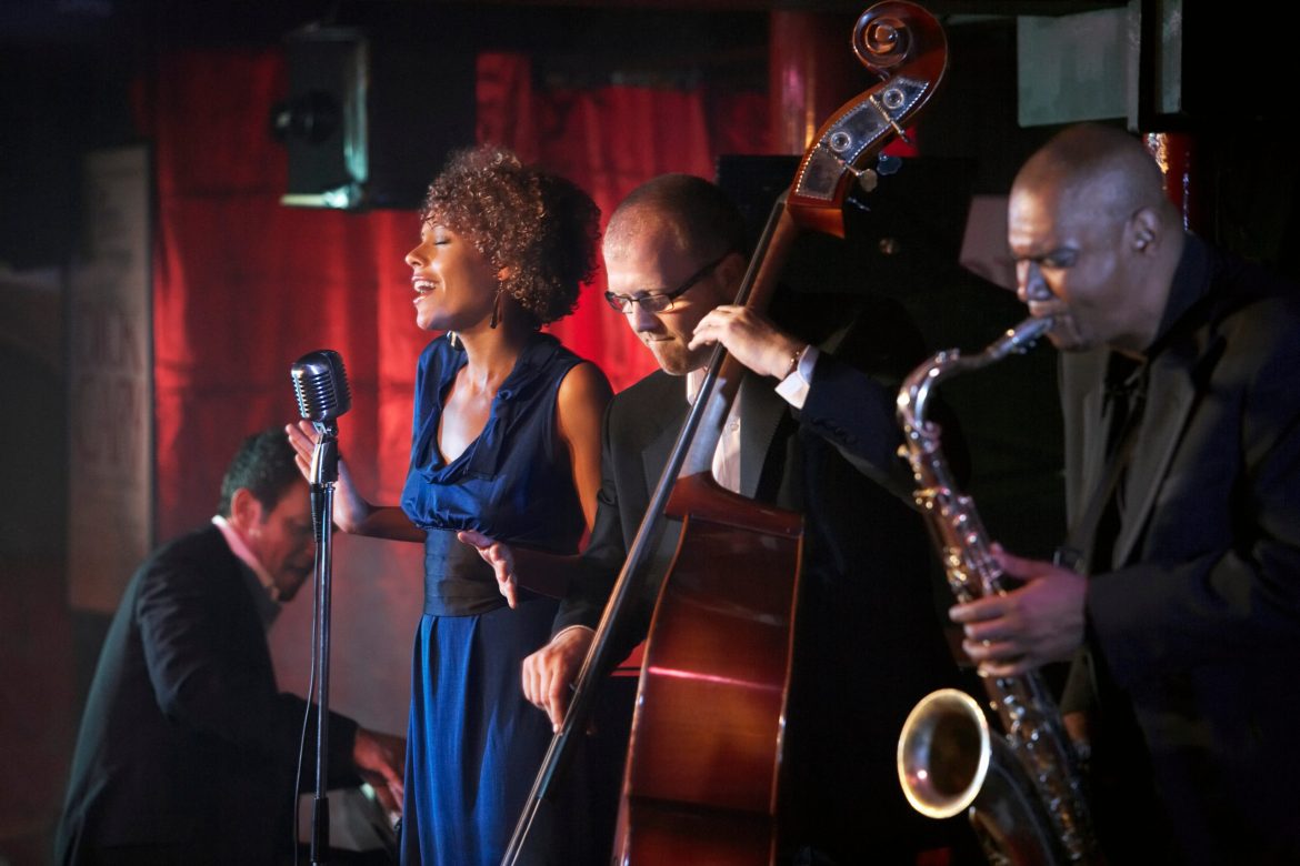 A jazz singer and band perform in a nightclub.