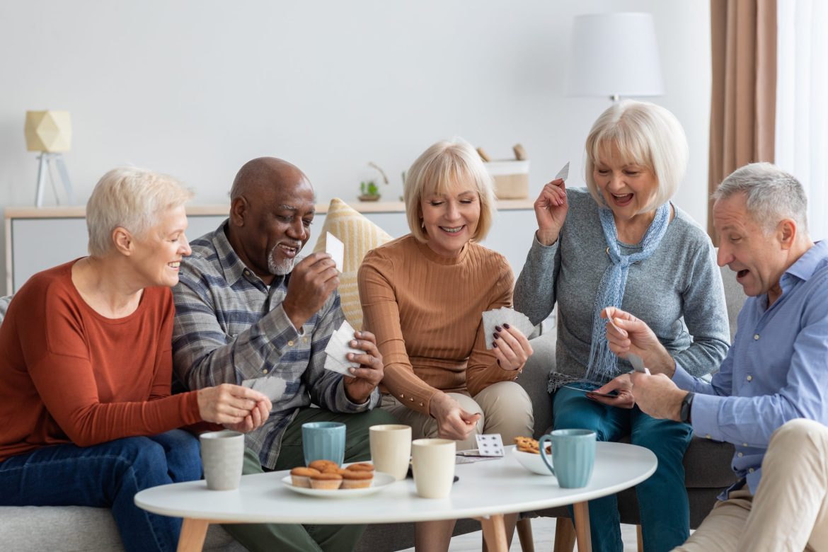 Group of older adults playing cards and drinking coffee.