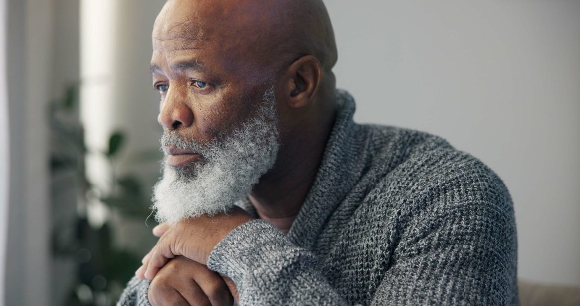 Lonely older man with beard looking sad.
