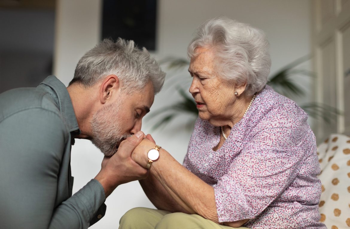 Son kisses the hands of his mother, who is living with dementia.