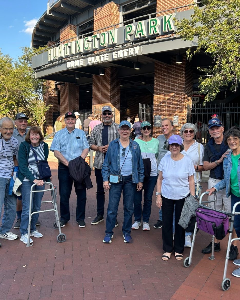 A group of Friendship Village of Dublin stand outsides the gates to Huntington Park on a trip to see the Columbus Clippers play baseball.