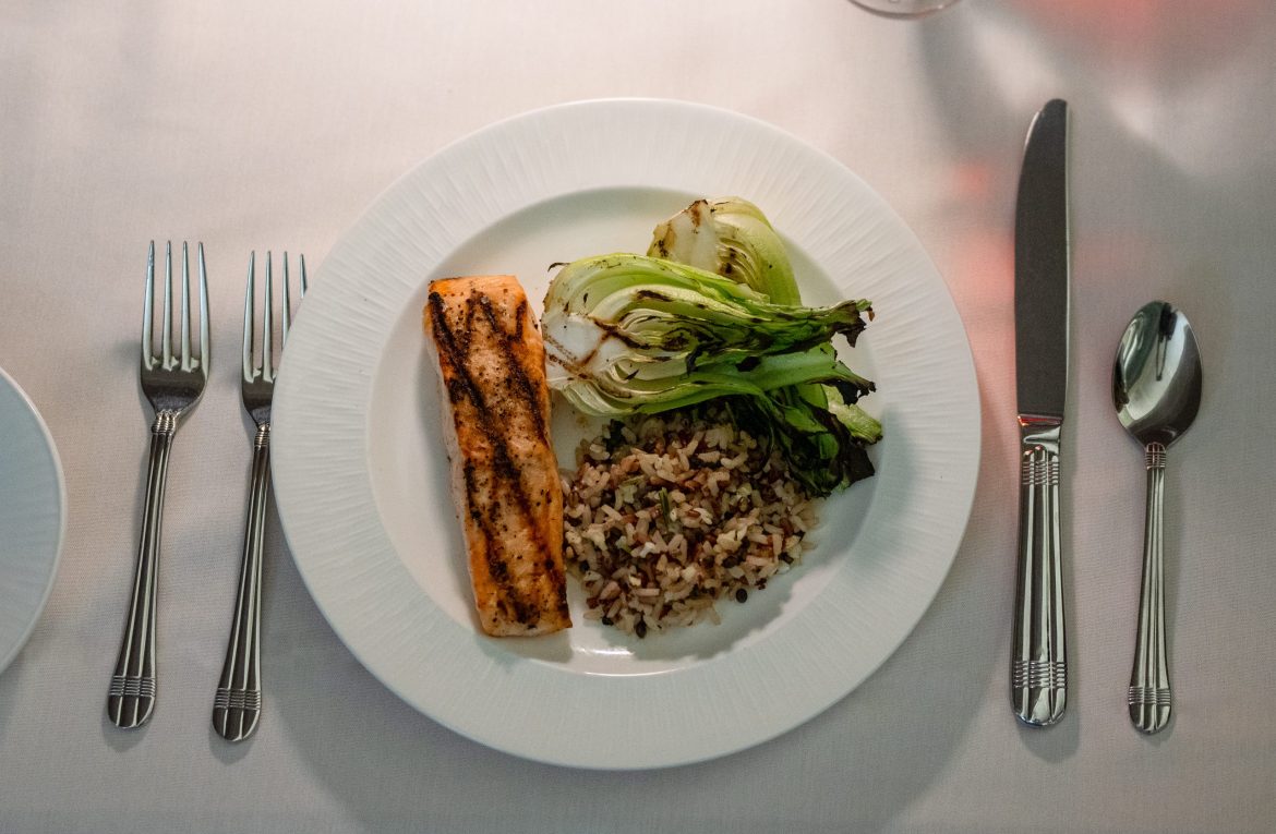 A plate with a salmon fillet, grilled leafy greens and rice pilaf prepared by the Friendship Village of Dublin culinary program.