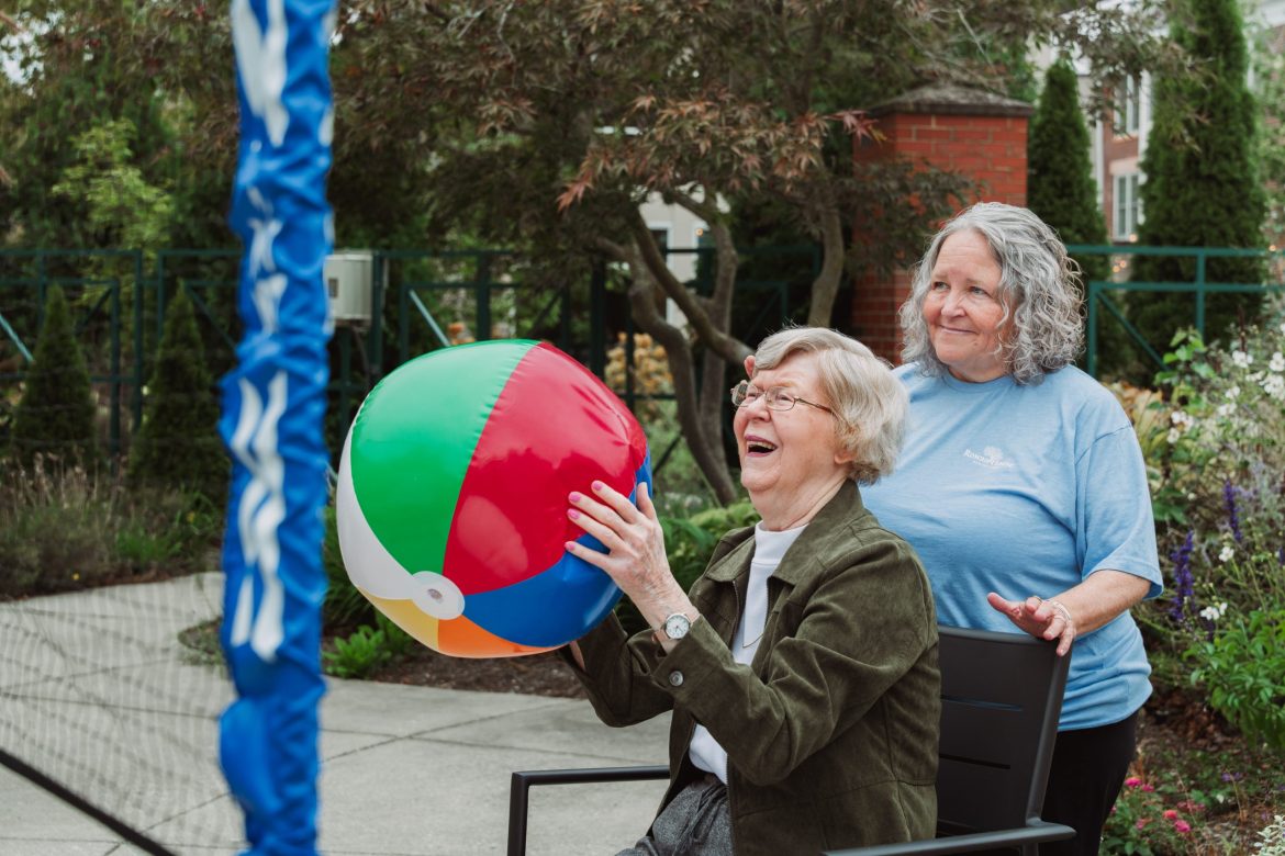 A Resident in memory care completes activity with a beach ball.