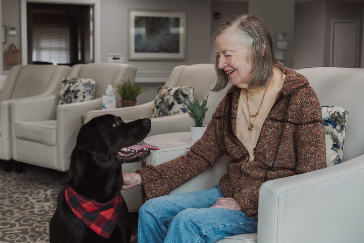 A Resident of Rowan House Memory Care visits with a dog as part of dementia care.