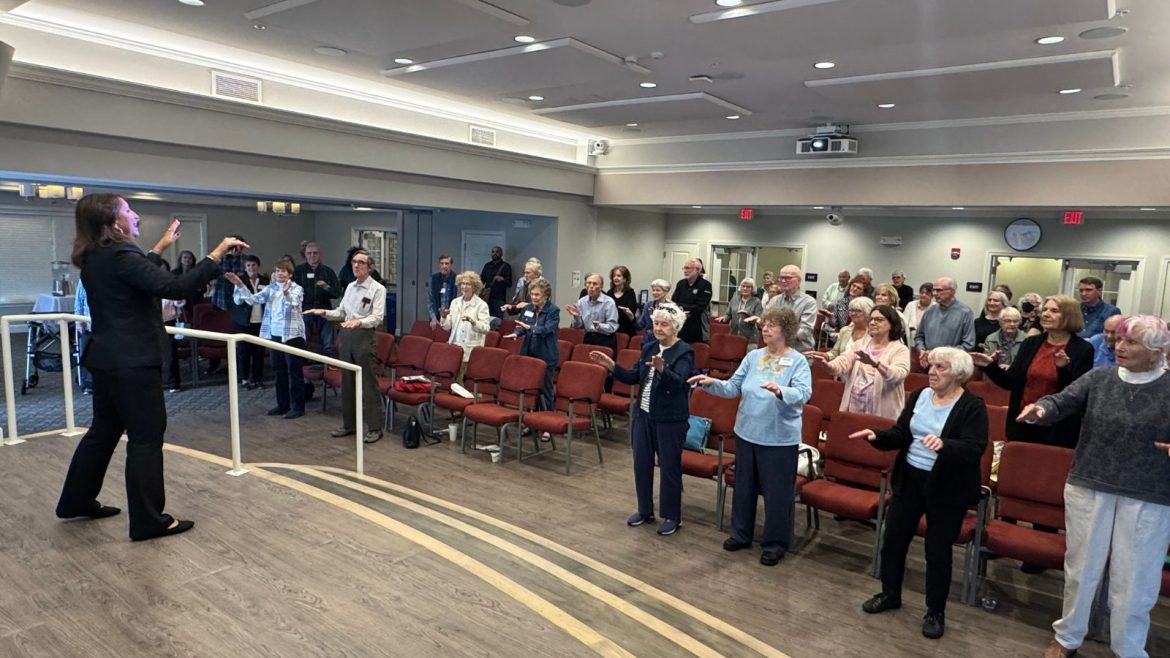 Dr. B. Melnyk leads a room full of seniors in a dance during her presentation on wellness.